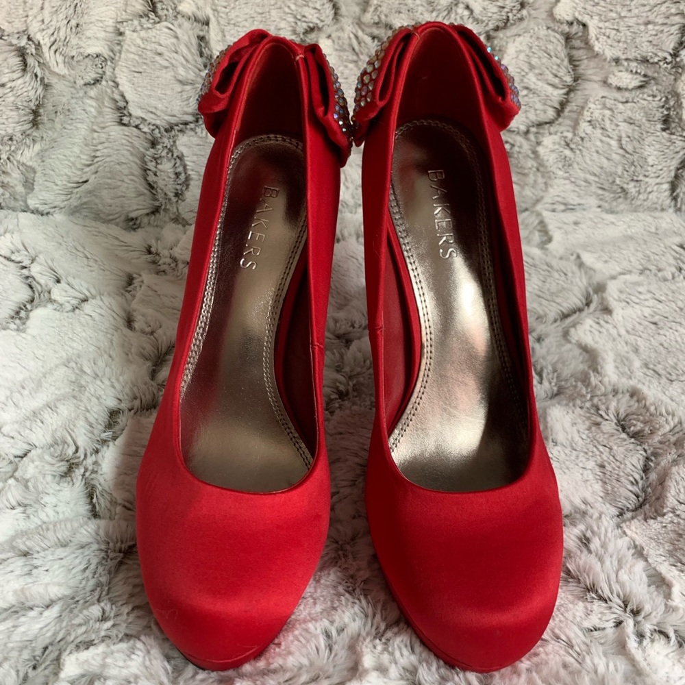 Red pump heels with jeweled bows on the back.